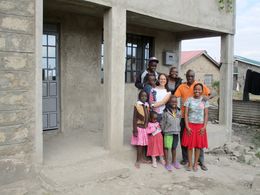 Bernhard und Bentina Alusi samt Familie und Gästen vor ihrem neuen Haus, das noch ein Rohbau ist.